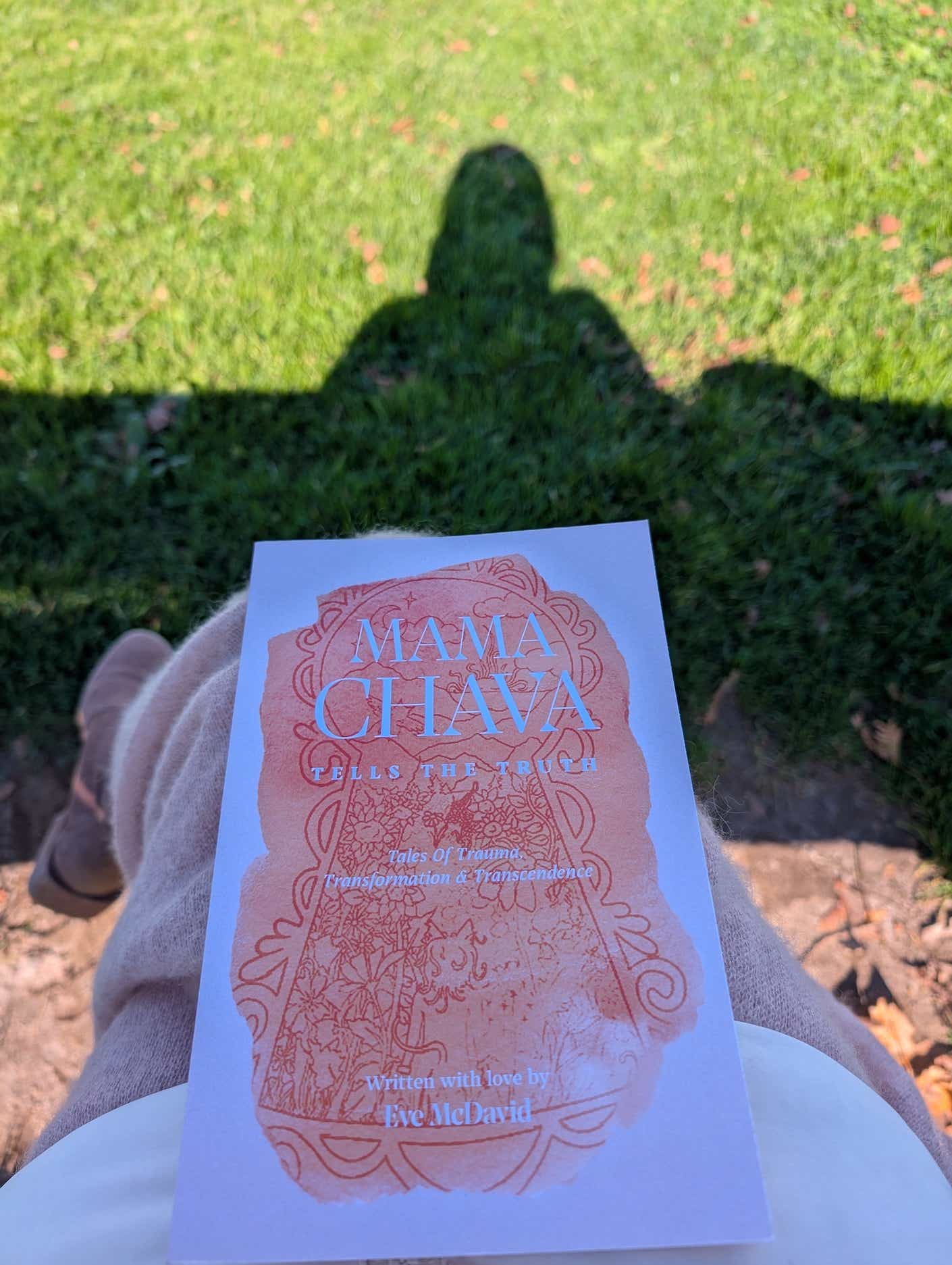 a woman holding a book called mama chava