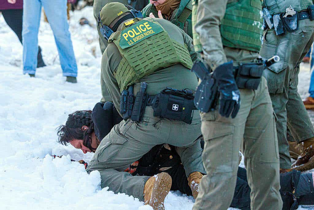 U.S. Border Patrol agents detain a person near a school.