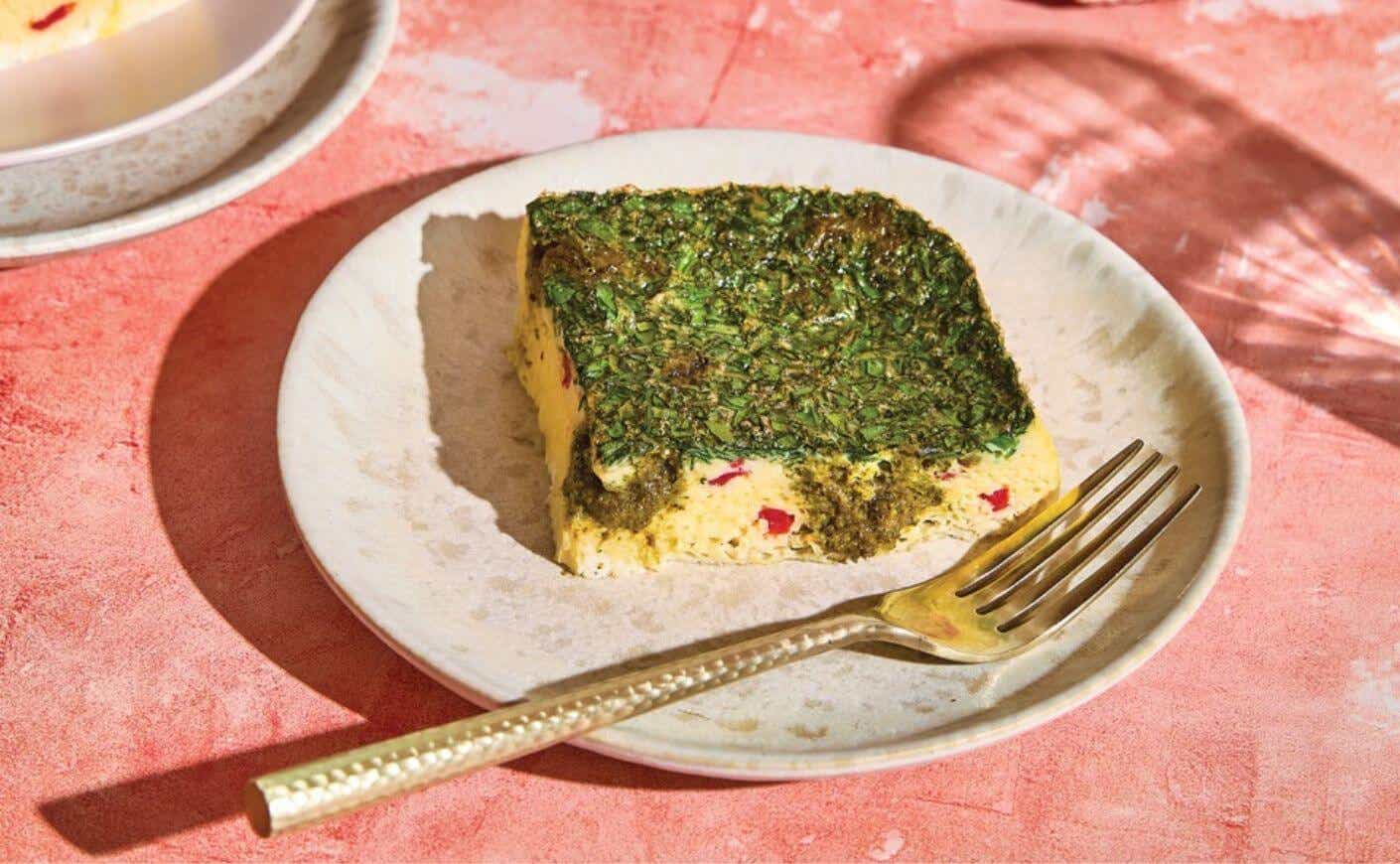 A square of pesto egg casserole on a plate.