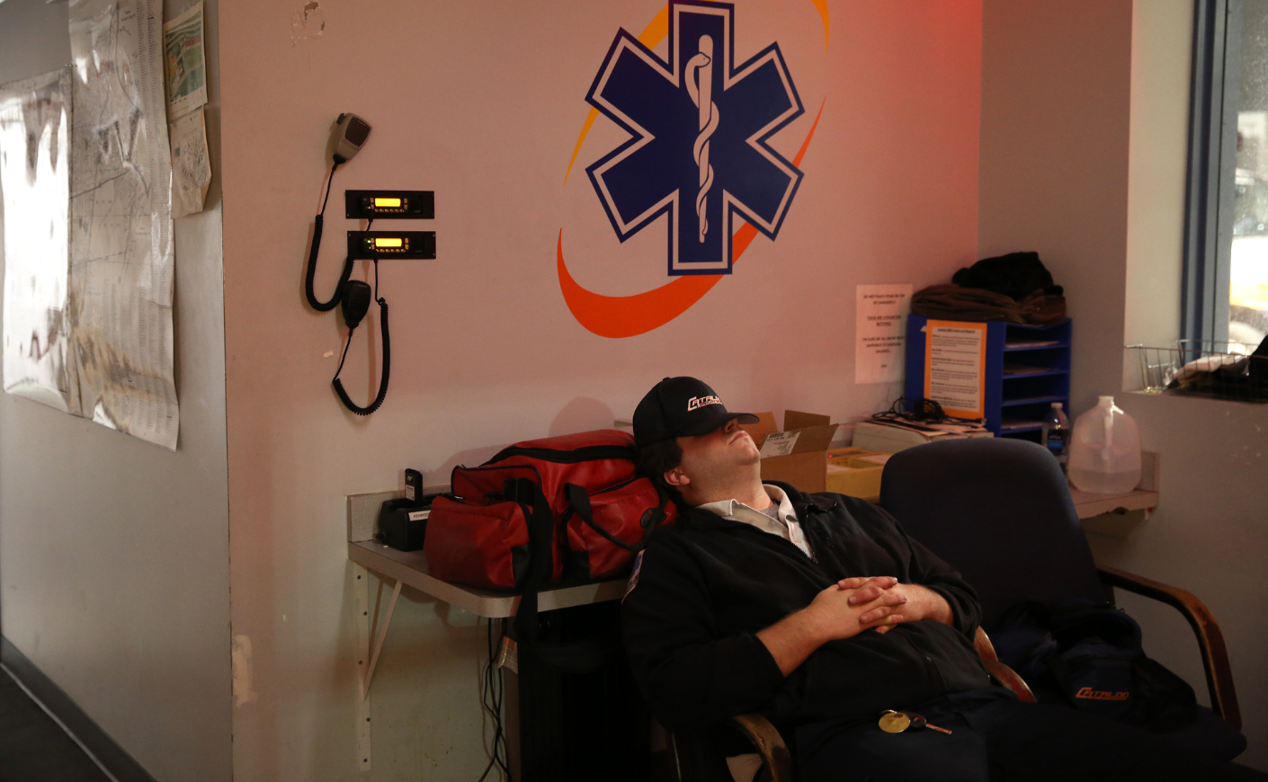 An EMT taking a nap on the job, his hat over his eyes.