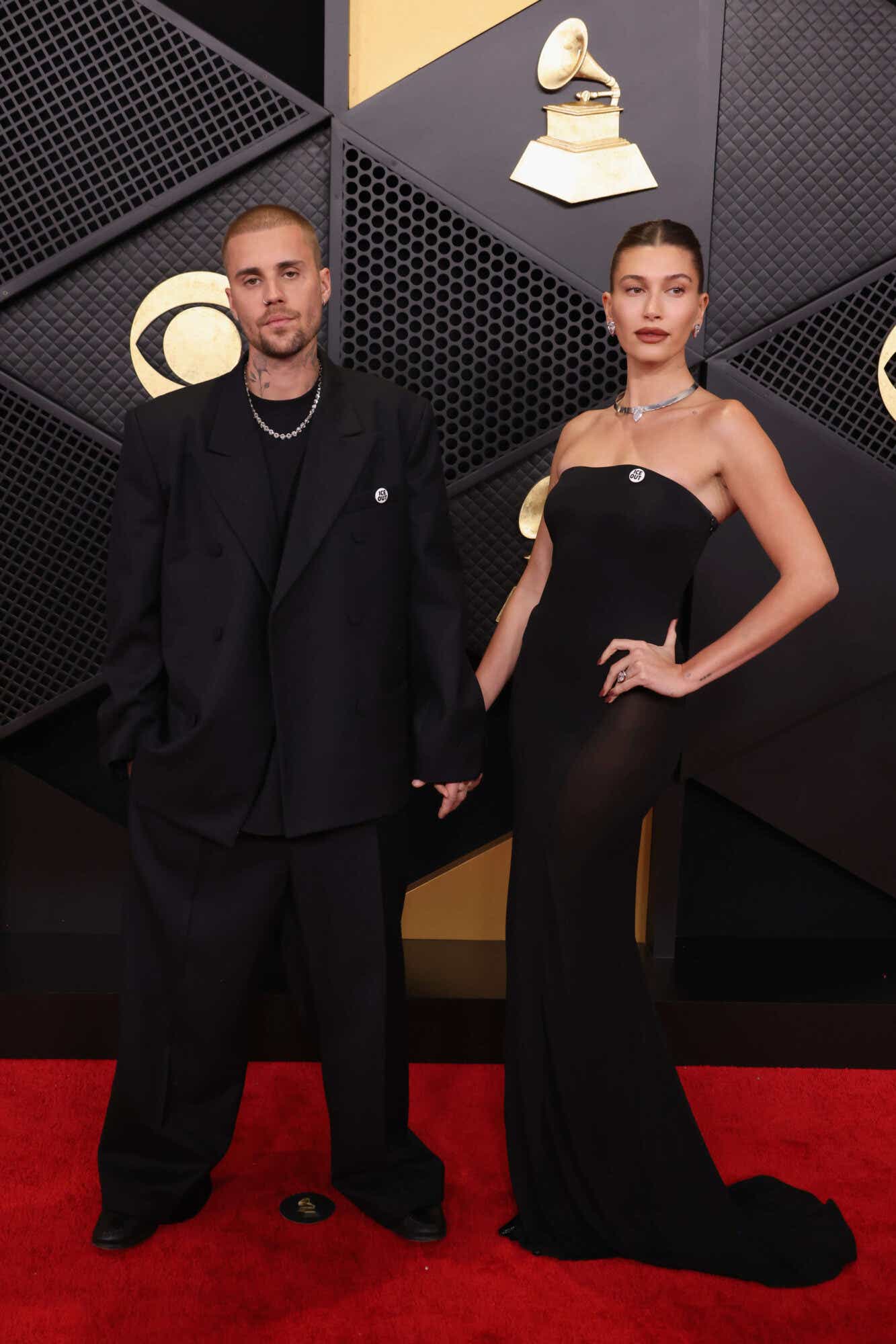 Justin and Hailey Bieber wear coordinating all-black outfits and ICE OUT pins.