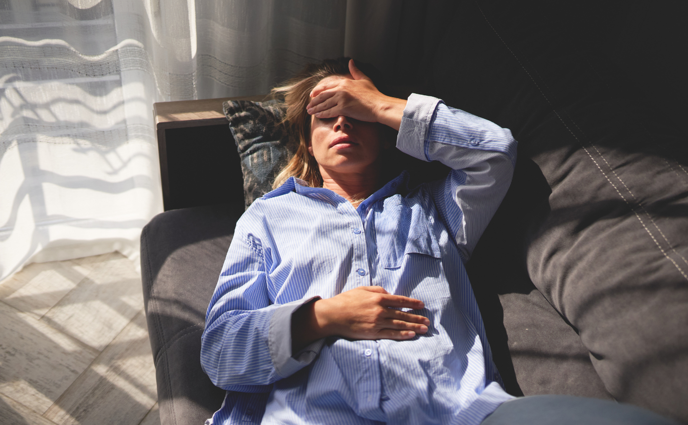 woman lying down holding head