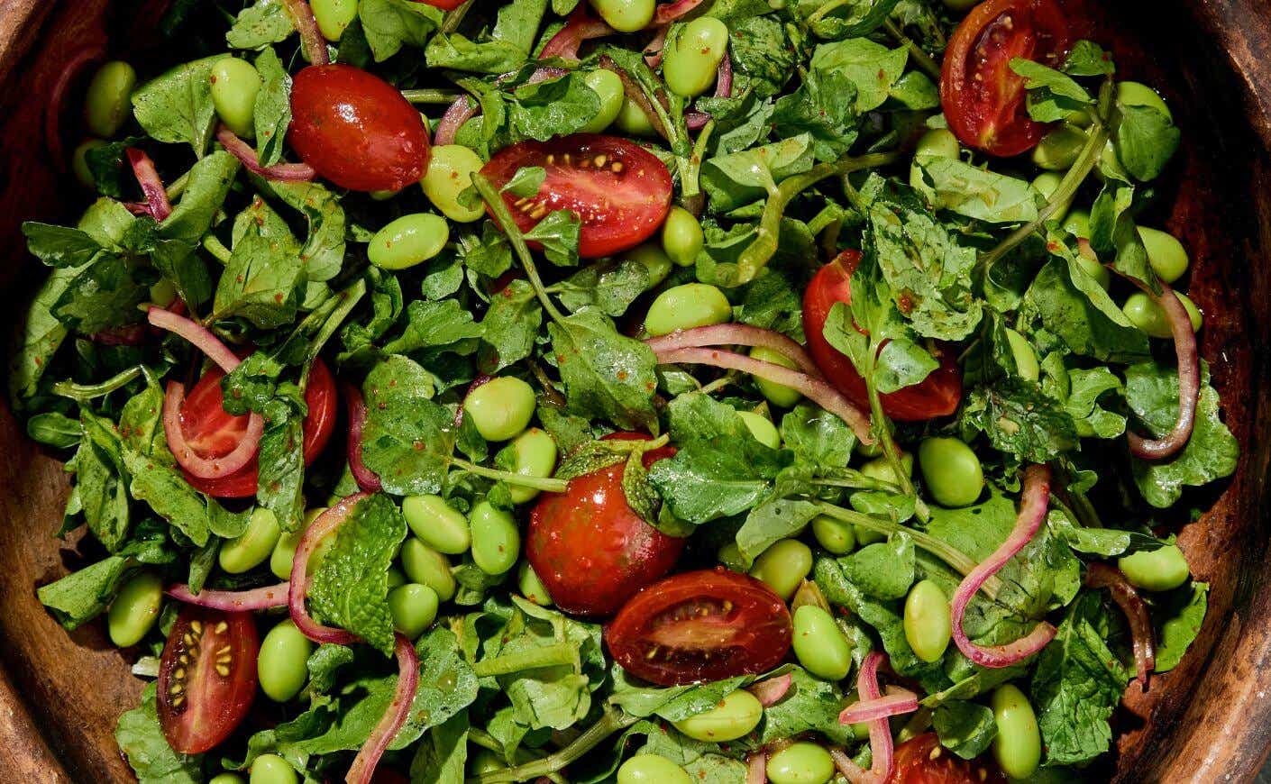 A bowl of edamame bean and tomato salad.