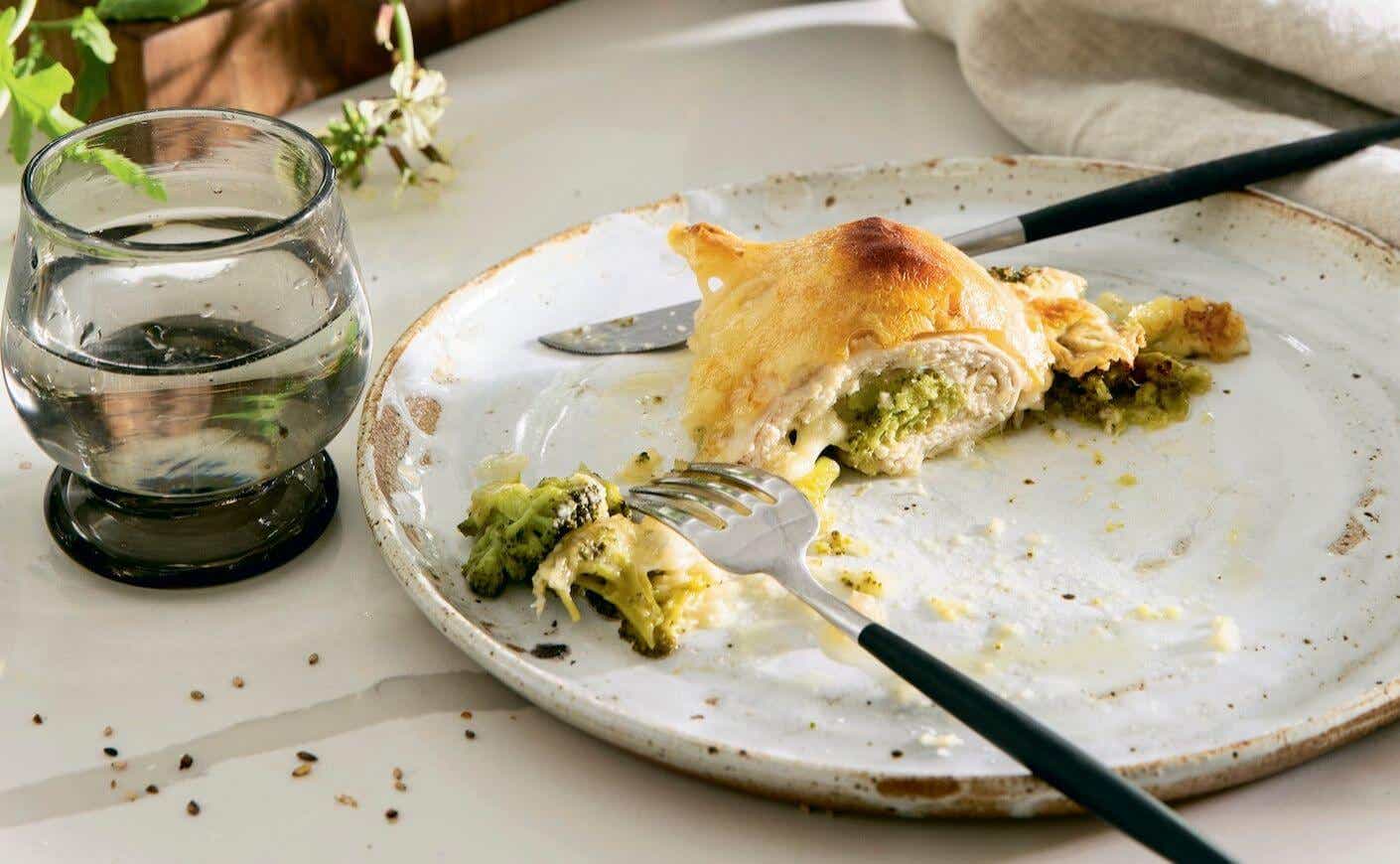 A plate of broccoli and Swiss cheese stuffed chicken.
