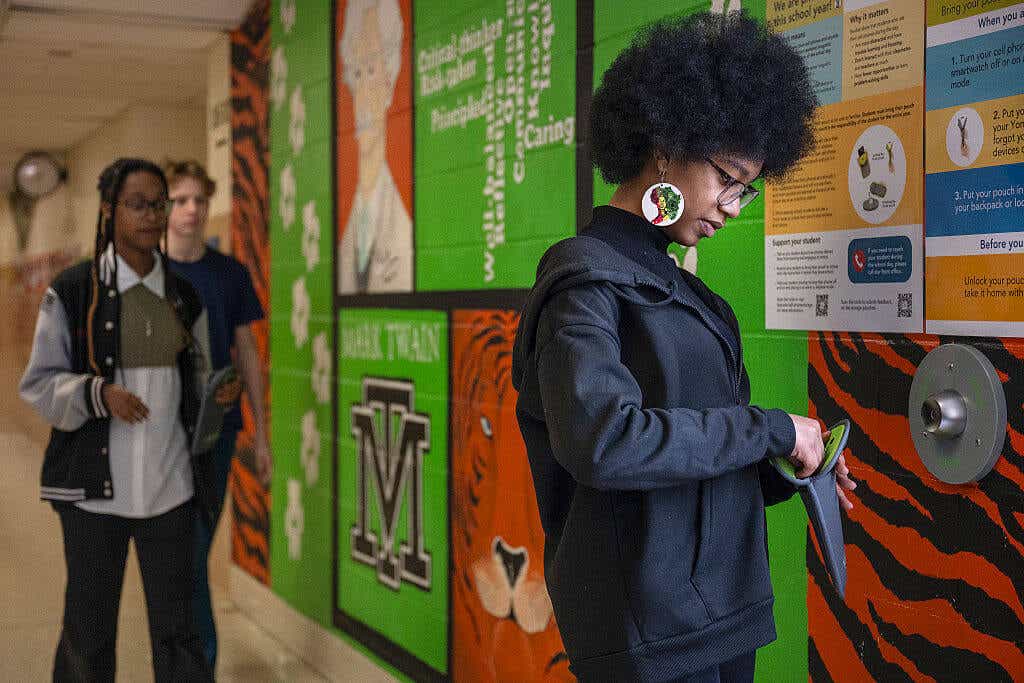 An eighth grader unlocks her cellphone from a pouch at Mark Twain Middle School in Alexandria, Va., in March 2025.