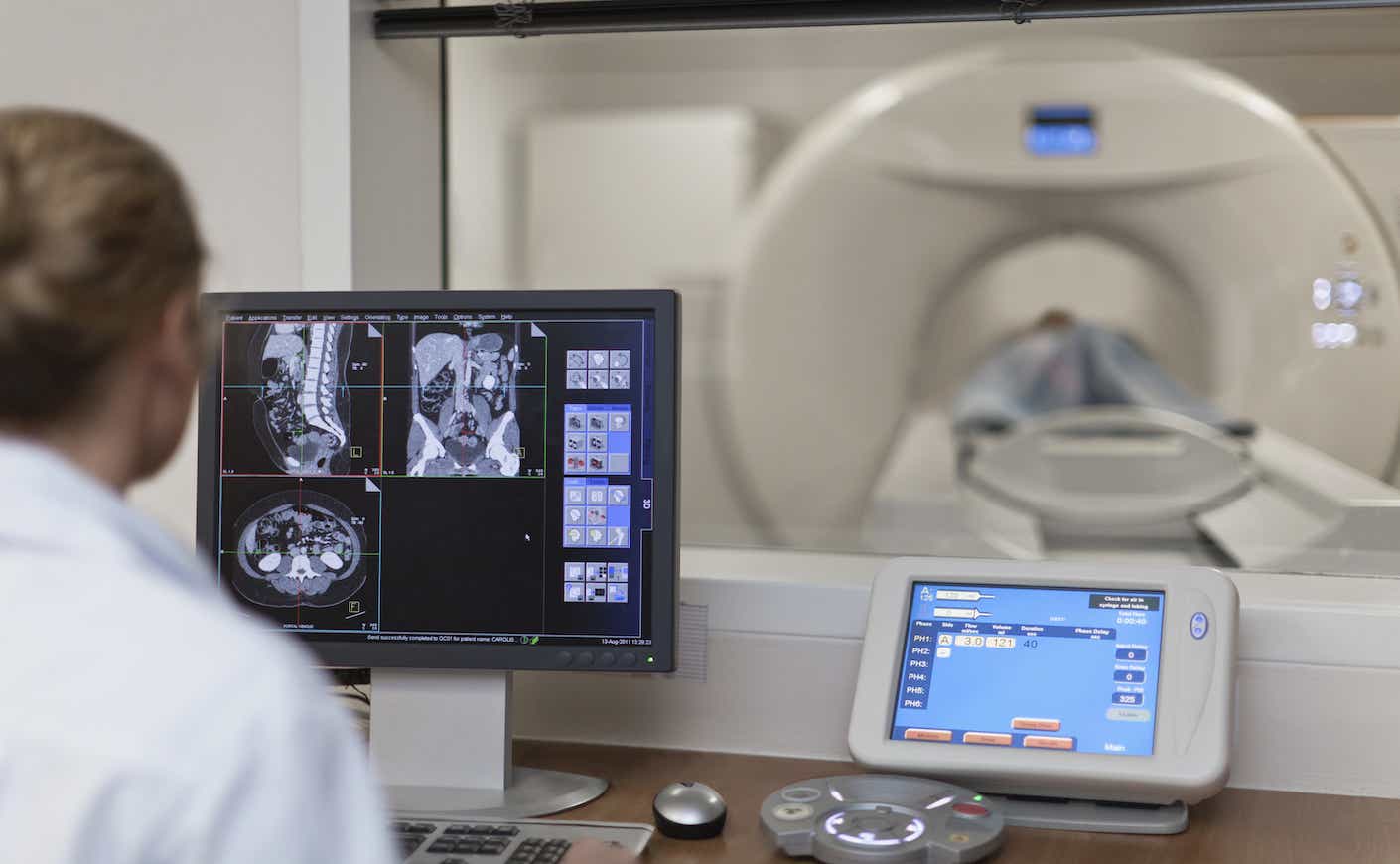 Doctor operating CT scanner in hospital