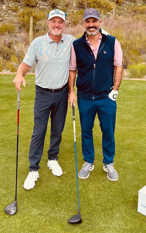 Jerry Kelly and John Molner on a golf course holding golf clubs