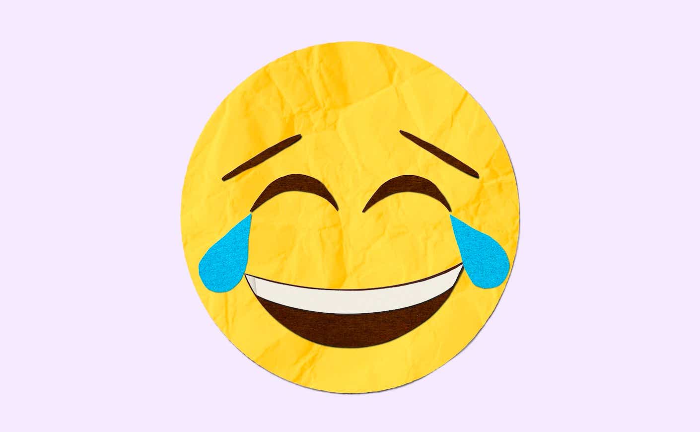 the laughing-crying emoji on a pink background