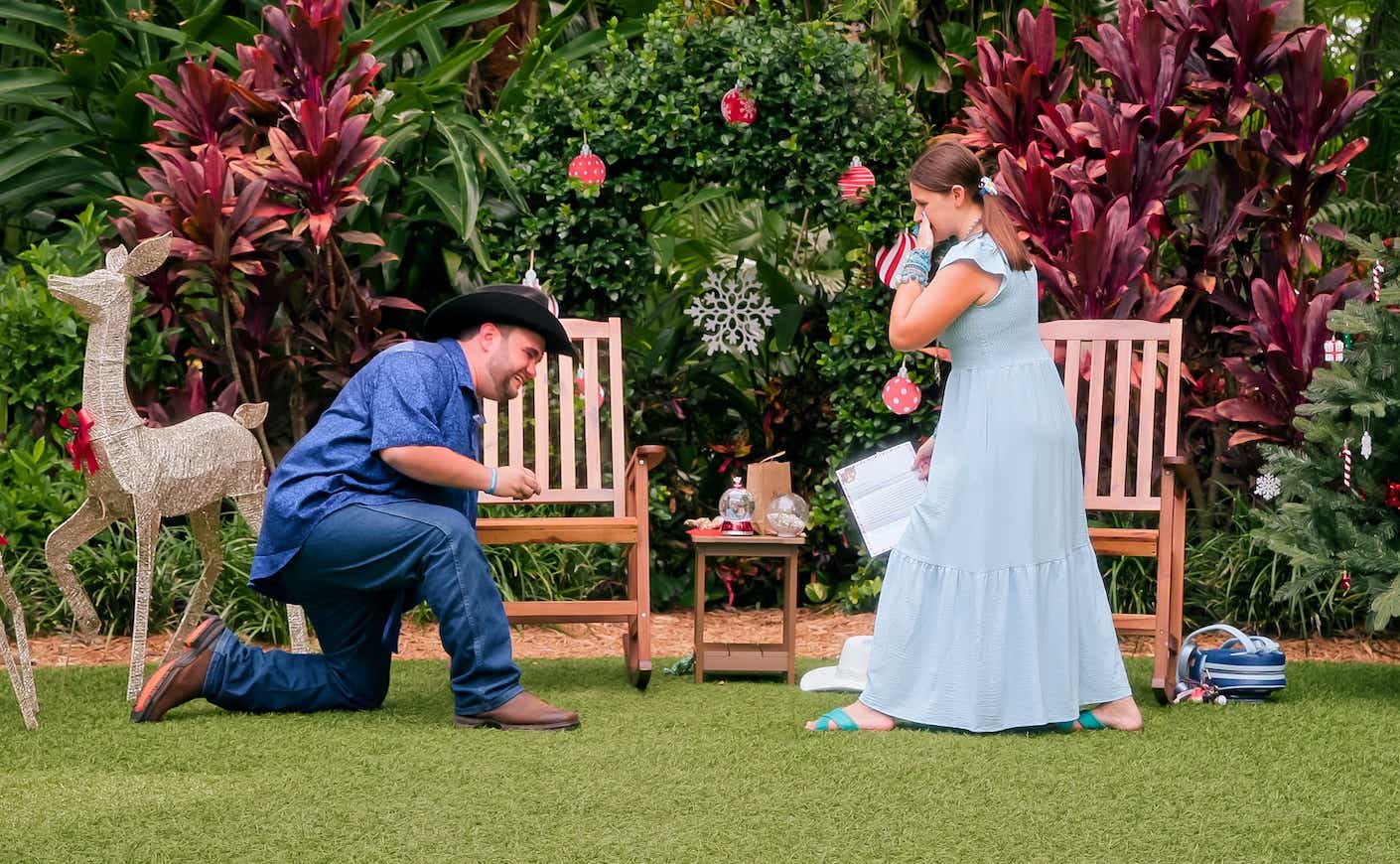 a man in a cowboy hat gets down on one knee to propose to a woman from Love on the Spectrum in a garden