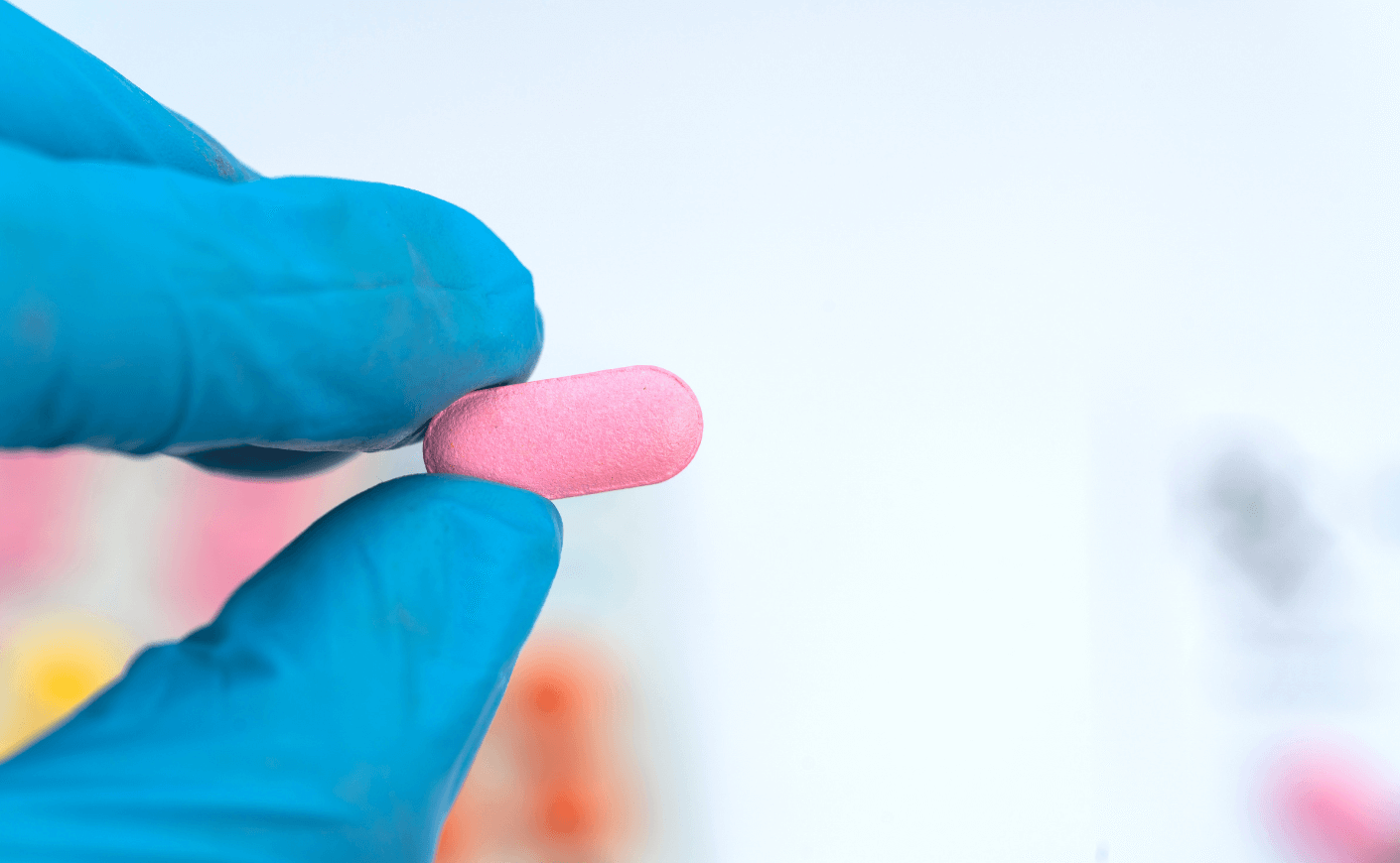 hand holding pink pill