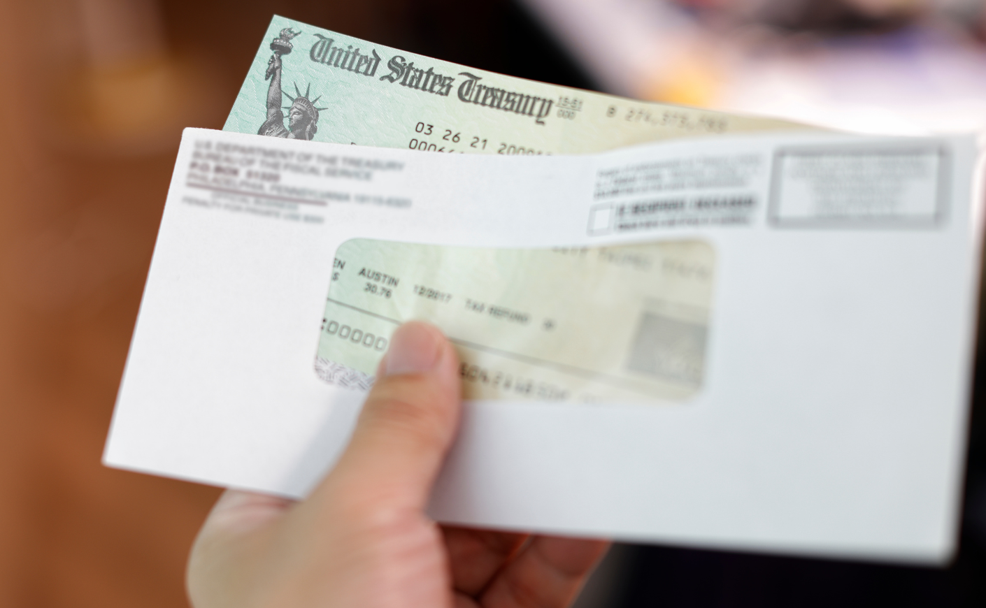 Close-up of a hand holding a tax refund check