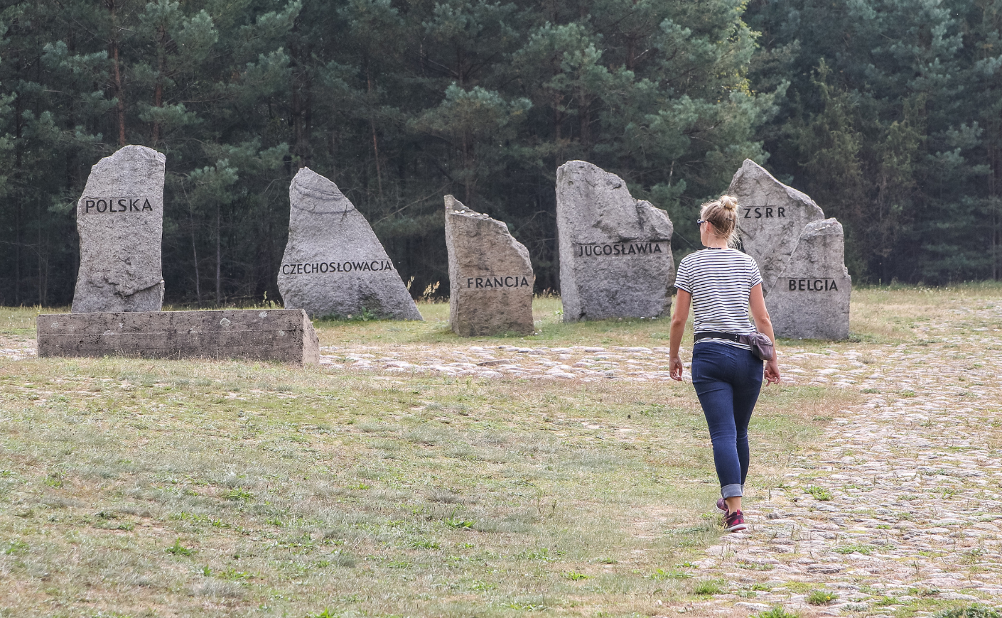 Woman walking towards memorial site honoring the hundreds of thousands who were killed at Treblinka.