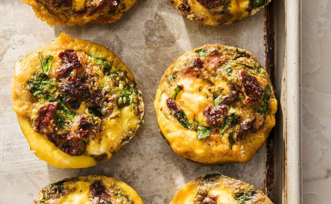 A pair of egg muffins on a baking sheet.
