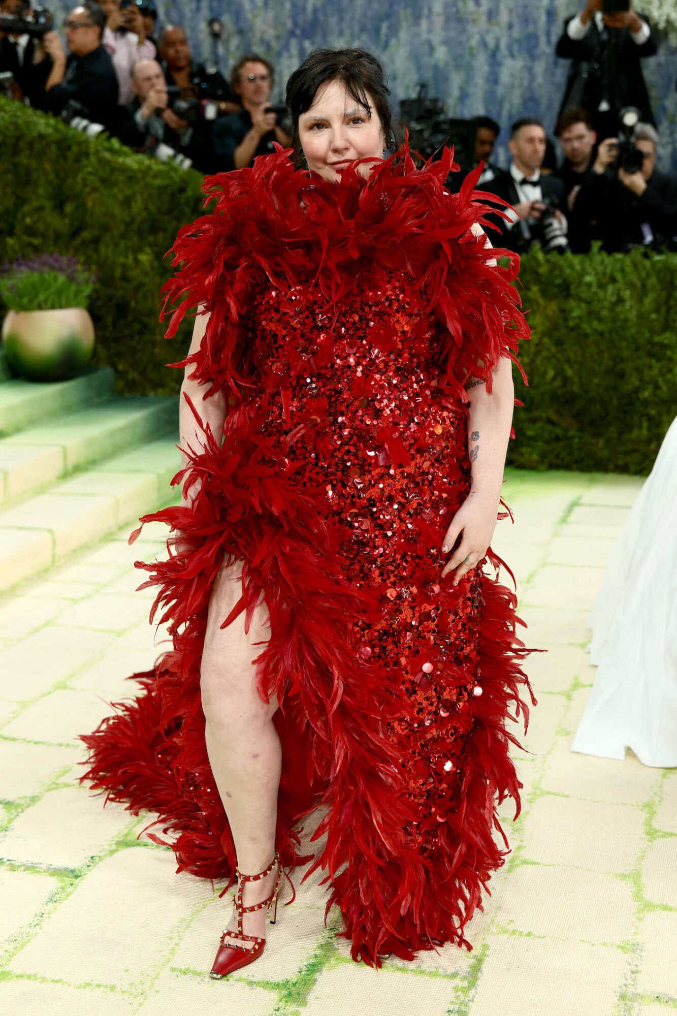 LEna dunham in a red gown at the 2026 met gala red carpet