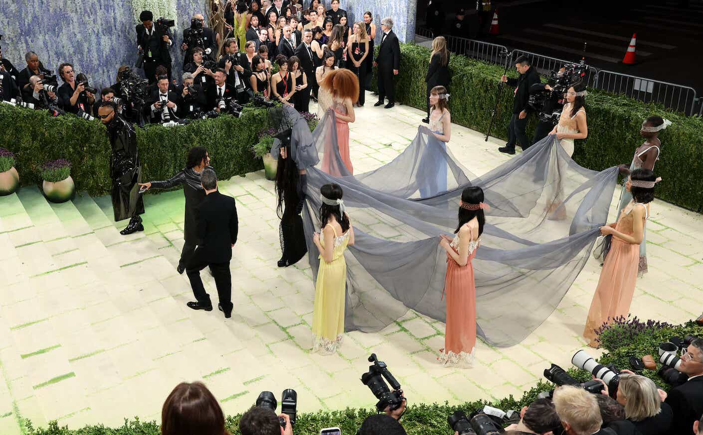 madonna in a dress with a train held up by 6 women at the 2026 met gala