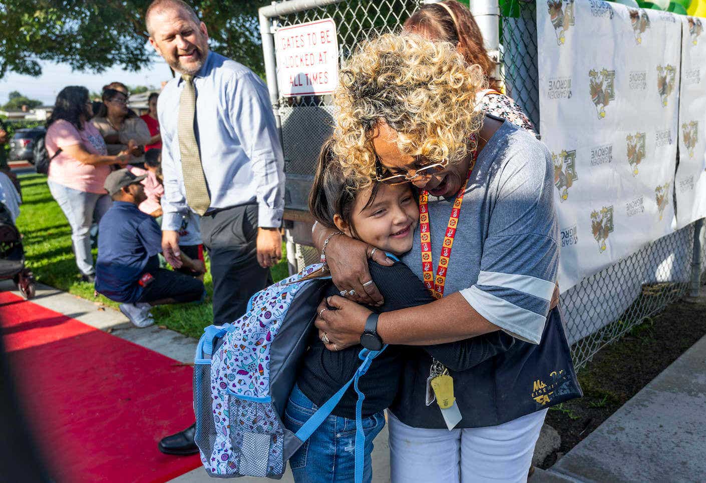 A student gets a hug from student supervisor Miss Pam as students returned for the first day of class at Eisenhower Elementary School in Garden Grove, CA.