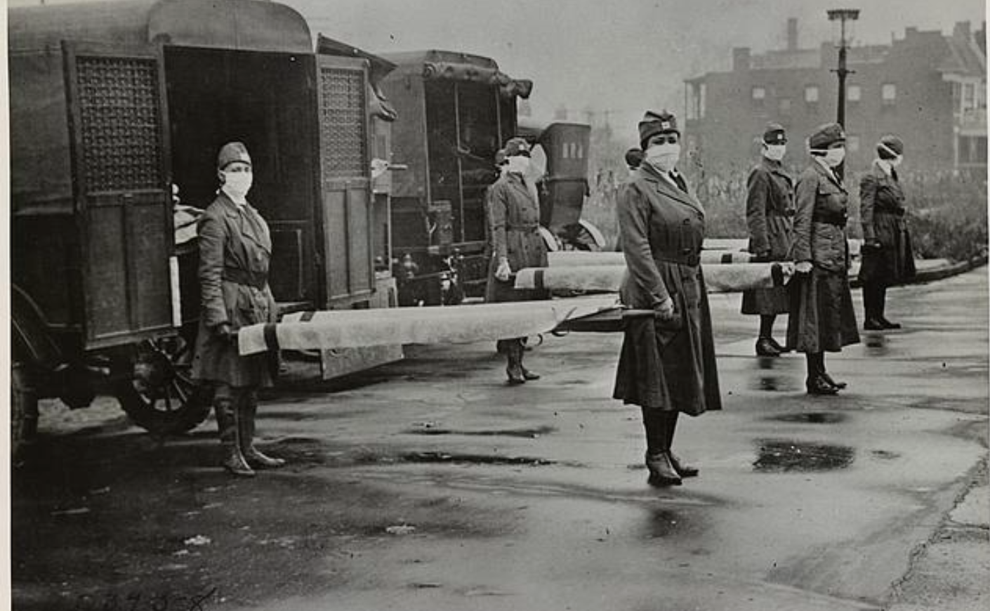 army medics with masks on standing in front of trucks