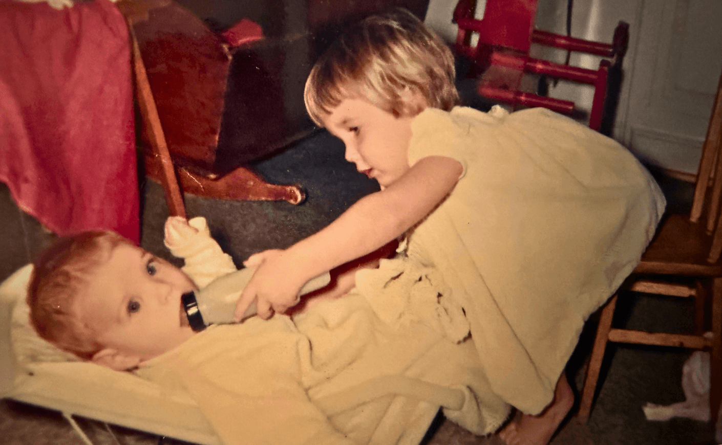 a child giving a baby a bottle
