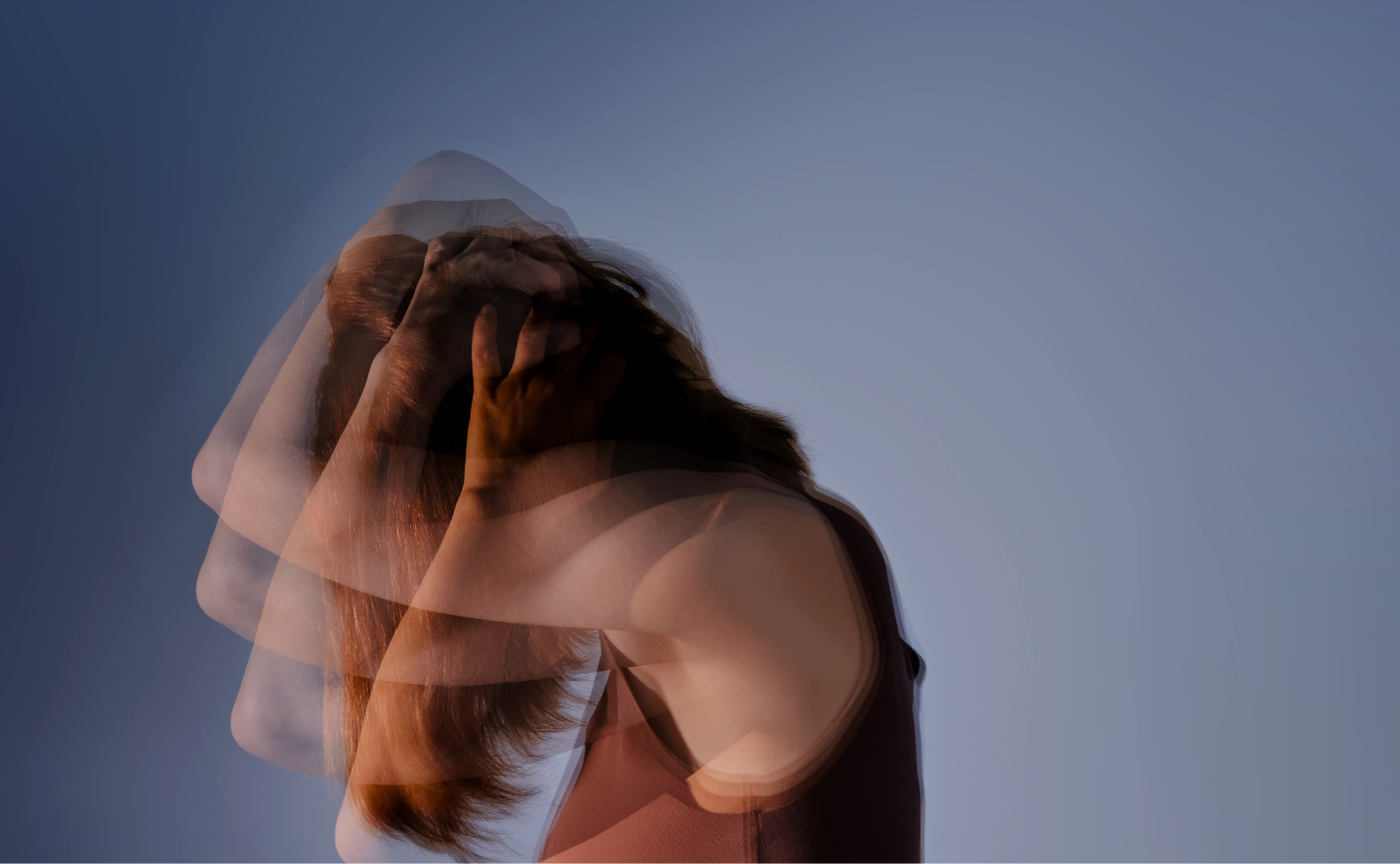 blurred photo of woman with her head in her hands, distressed