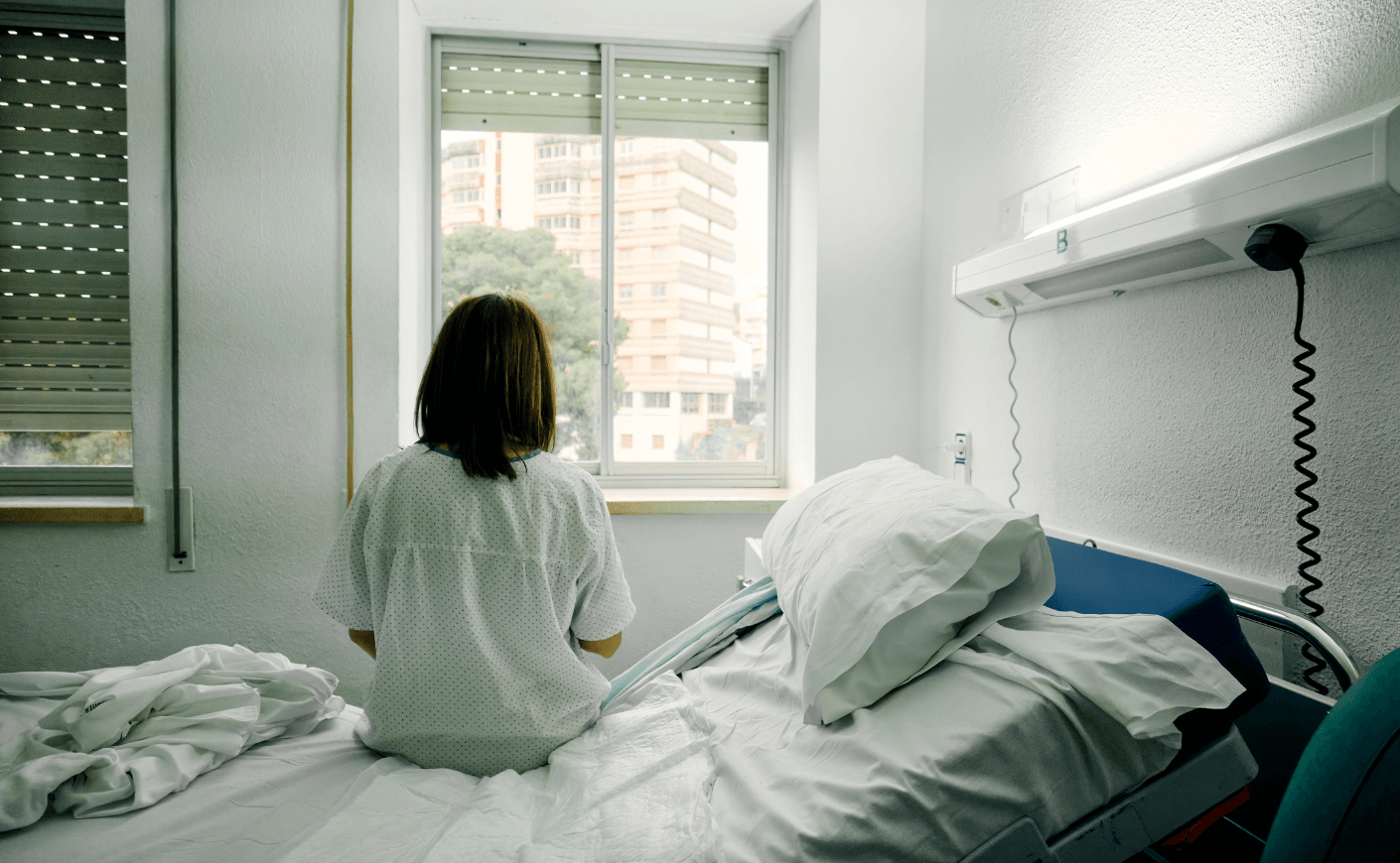 women in hospital bed alone