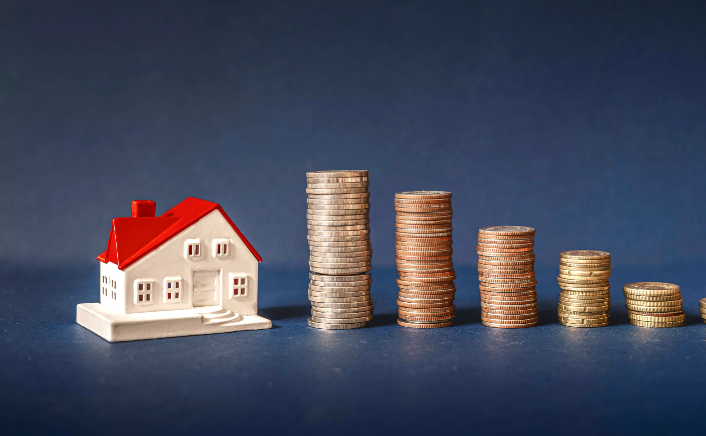 Stacks of coins next to a house