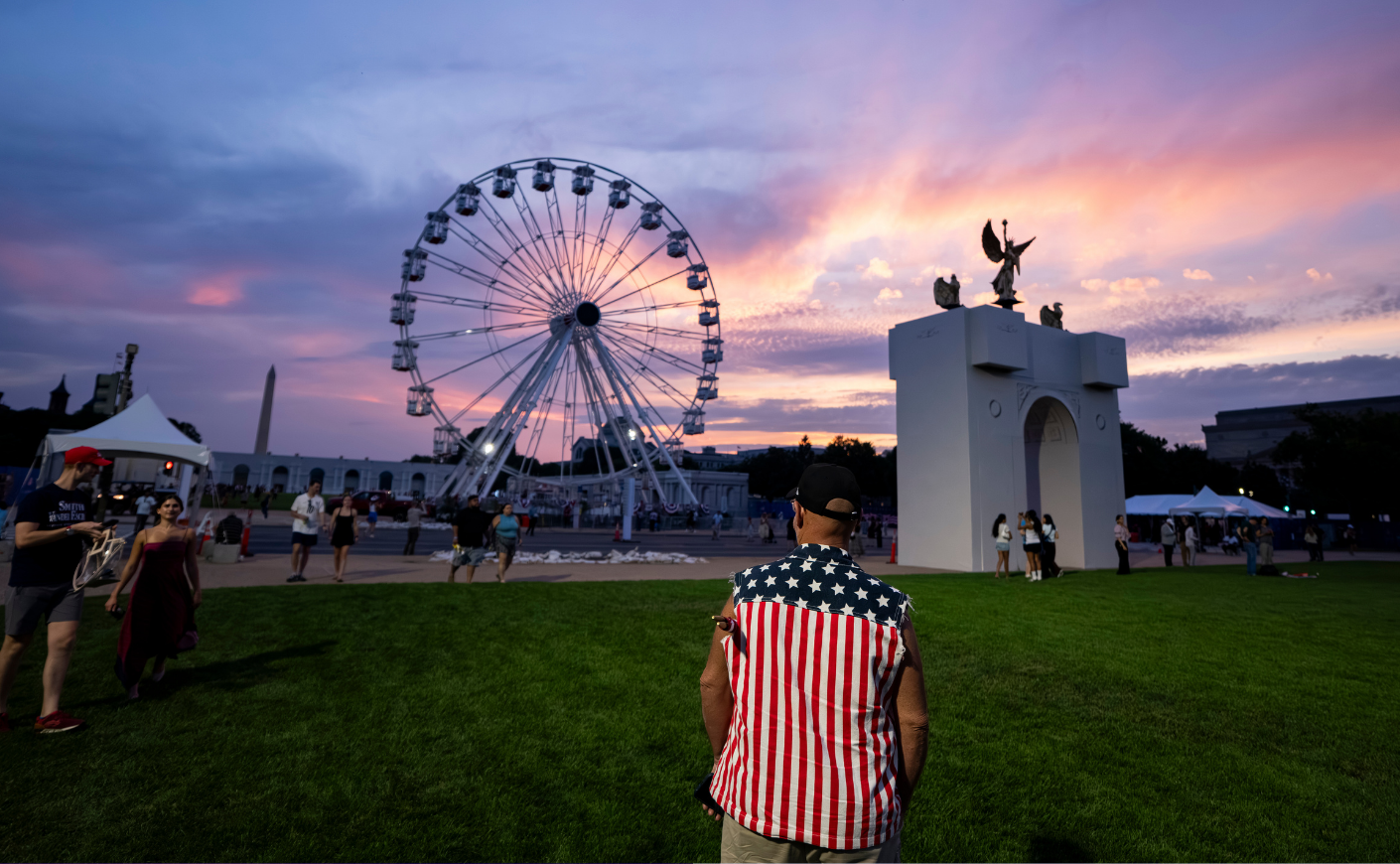 The sun sets behind a replica of the planned Triumphal Arch and the 110-foot "Freedom 250" ferris wheel on the first day of the "Great American State Fair" on the National Mall.