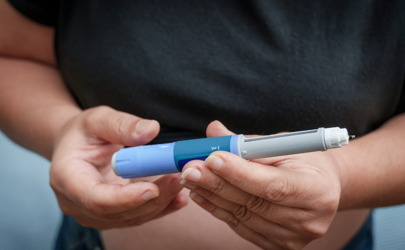 person holding injection pen