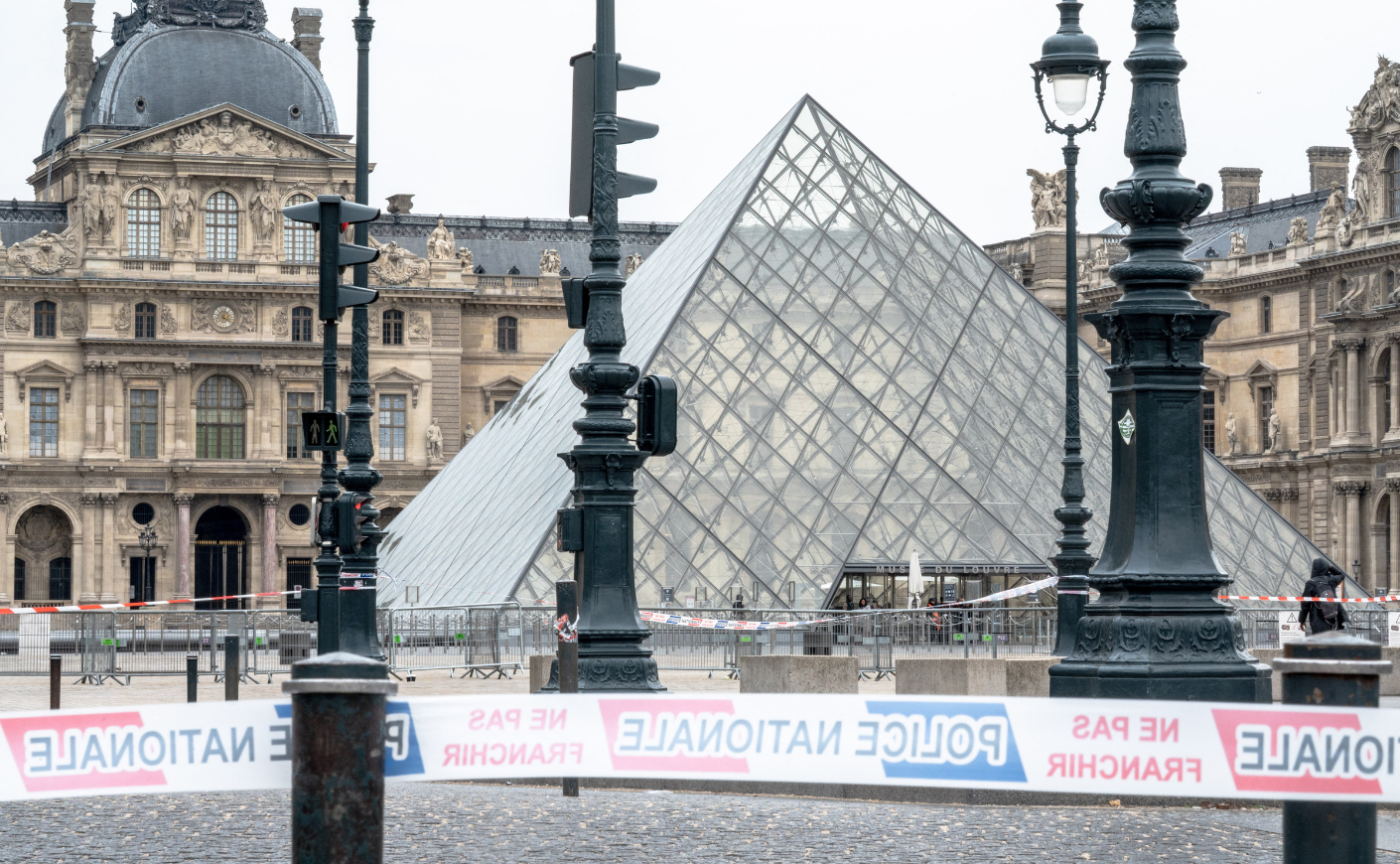 The glass pyramid of the Louvre after the heist, with police tape cordoning it off