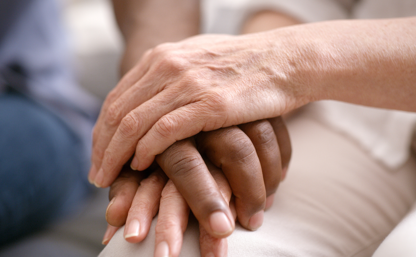 A black person and white person holding hands