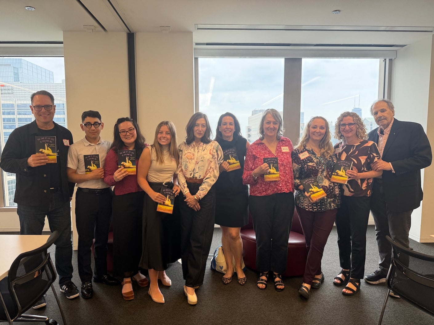 group of people holding up a book