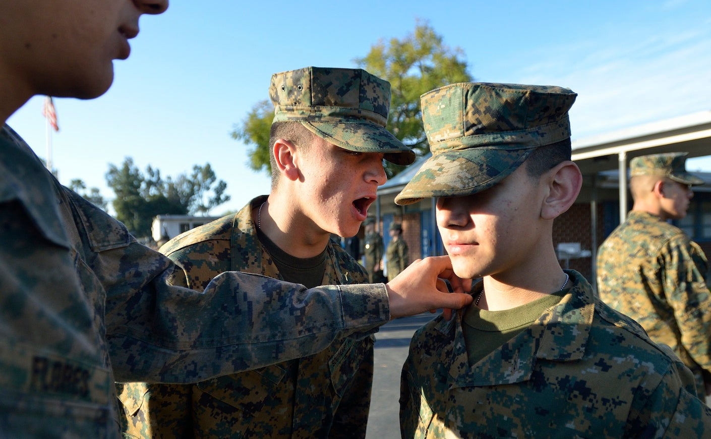 young men in military uniforms yelling