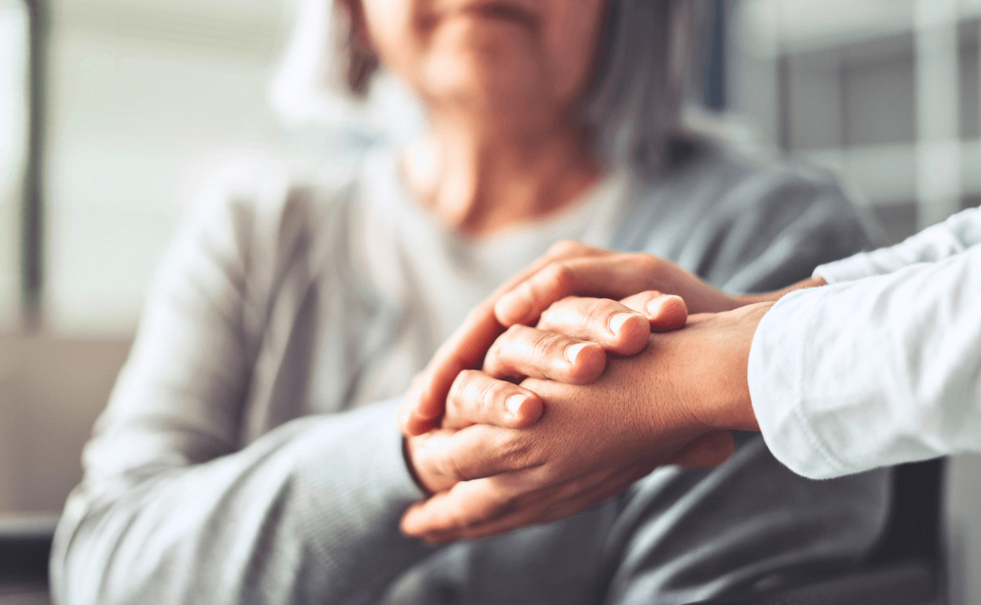 woman holding hands with elderly woman