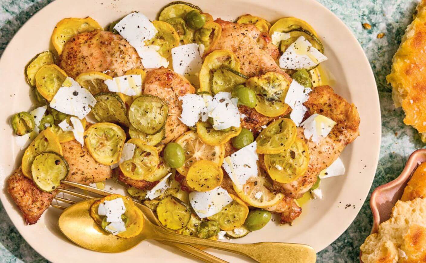 A sheet pan meal of chicken thighs and summer squash.