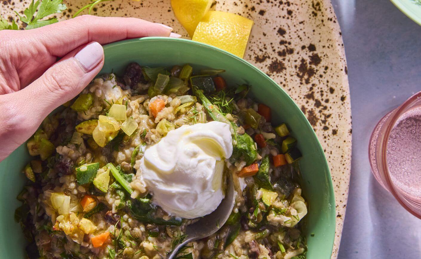 A bowl of lentils and rice topped with yogurt.