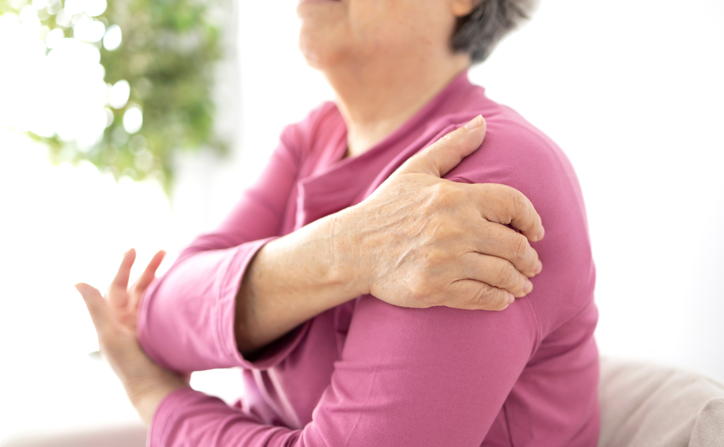 woman holding shoulder
