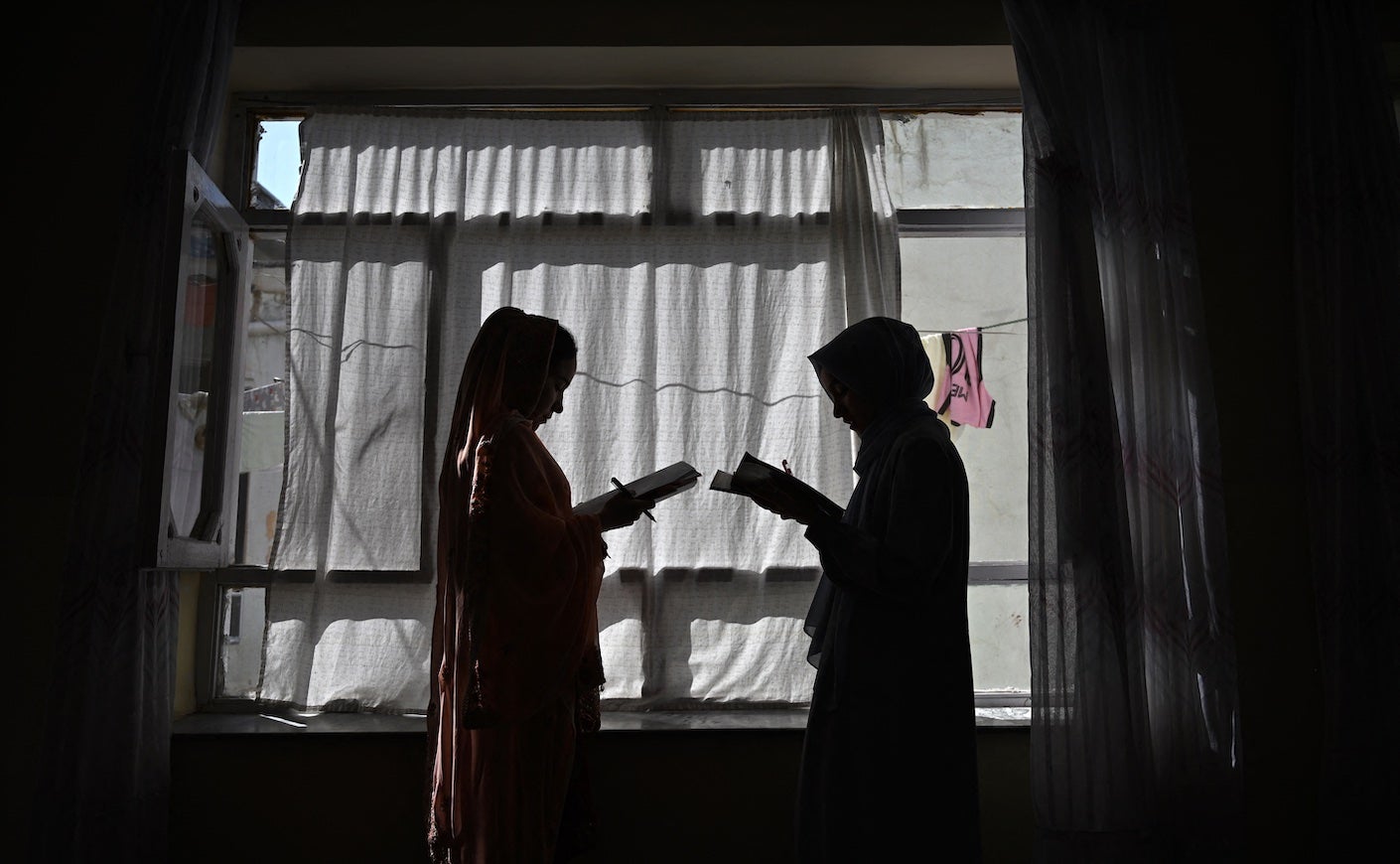 Afghan girls attending a lesson by their father at their residence in Kabul. Father after father AFP spoke to in Afghanistan about the education ban that stops their daughters going beyond primary school choked up in despair.