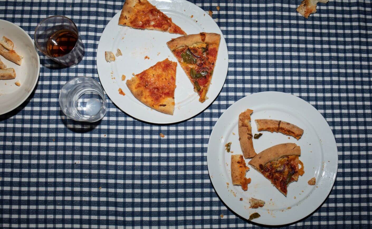A table with plates of leftover pizza on it
