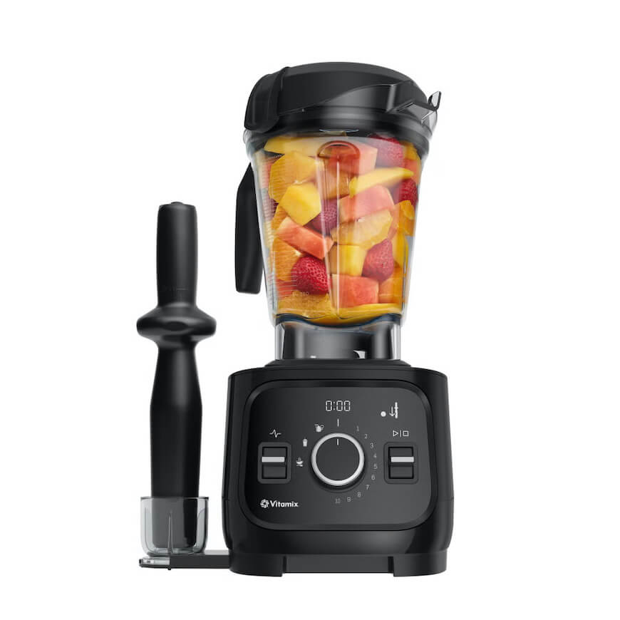 A Vitamix blender filled with chopped fruit.
