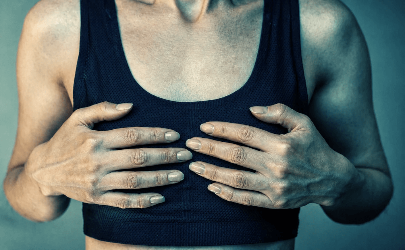 woman holding her breasts in sports bra
